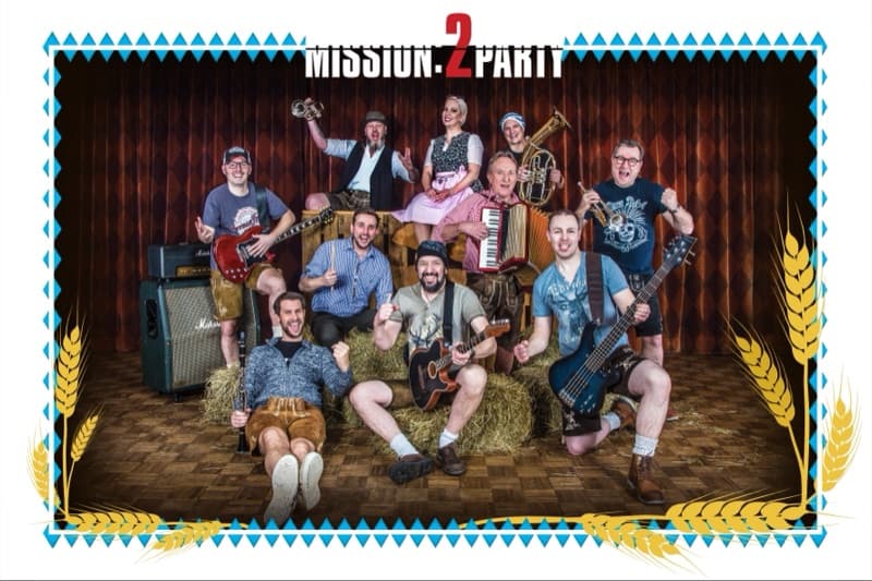 Mission:2Party Bandfoto im Oktoberfest-Look — Lederhosen und Dirndl mit Tuba und Akkordeon auf Strohballen